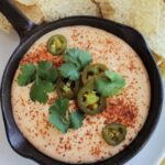 yellow queso dip in a mini cast iron skillet.