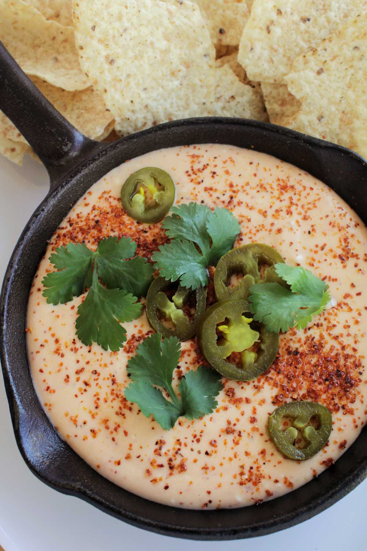 yellow queso topped with Tajin seasoning and jalapenos.
