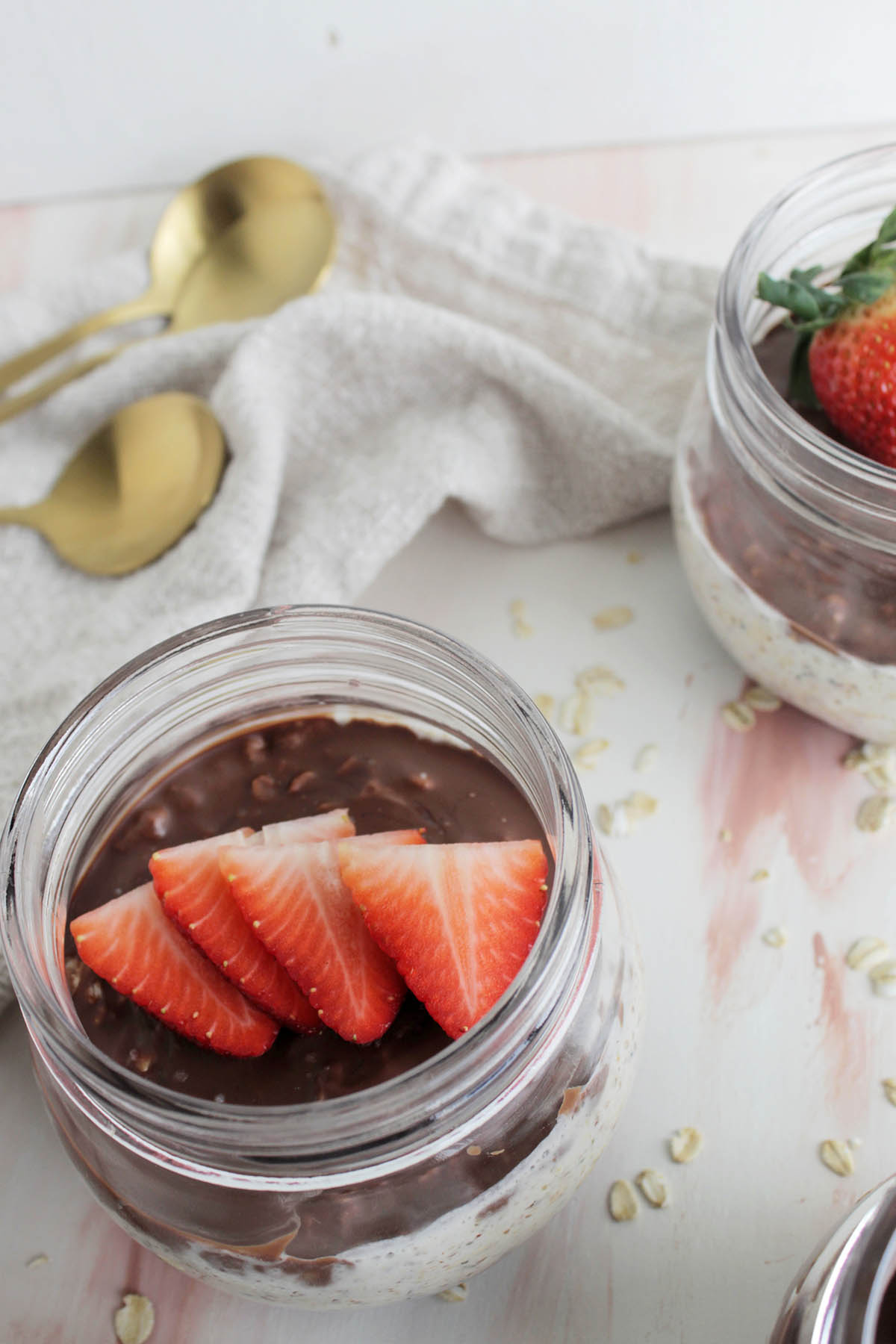 overnight oats topped with chocolate and sliced strawberries.