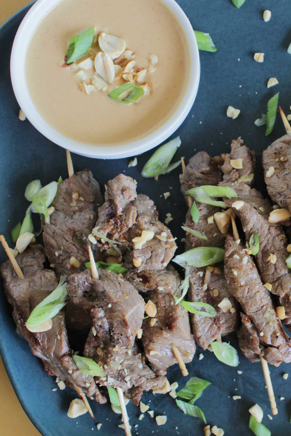 Asian steak skewers garnished with green onions.