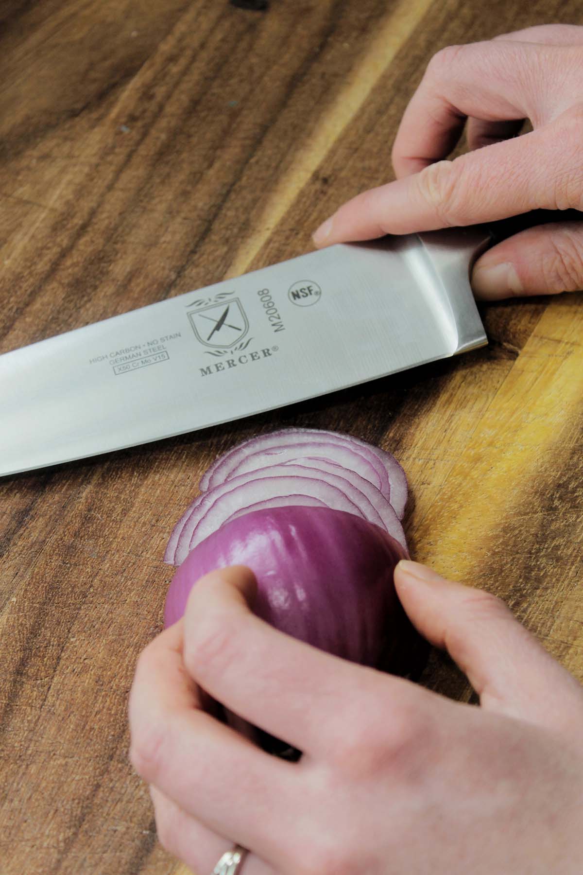 chef's knife next to onion slices.