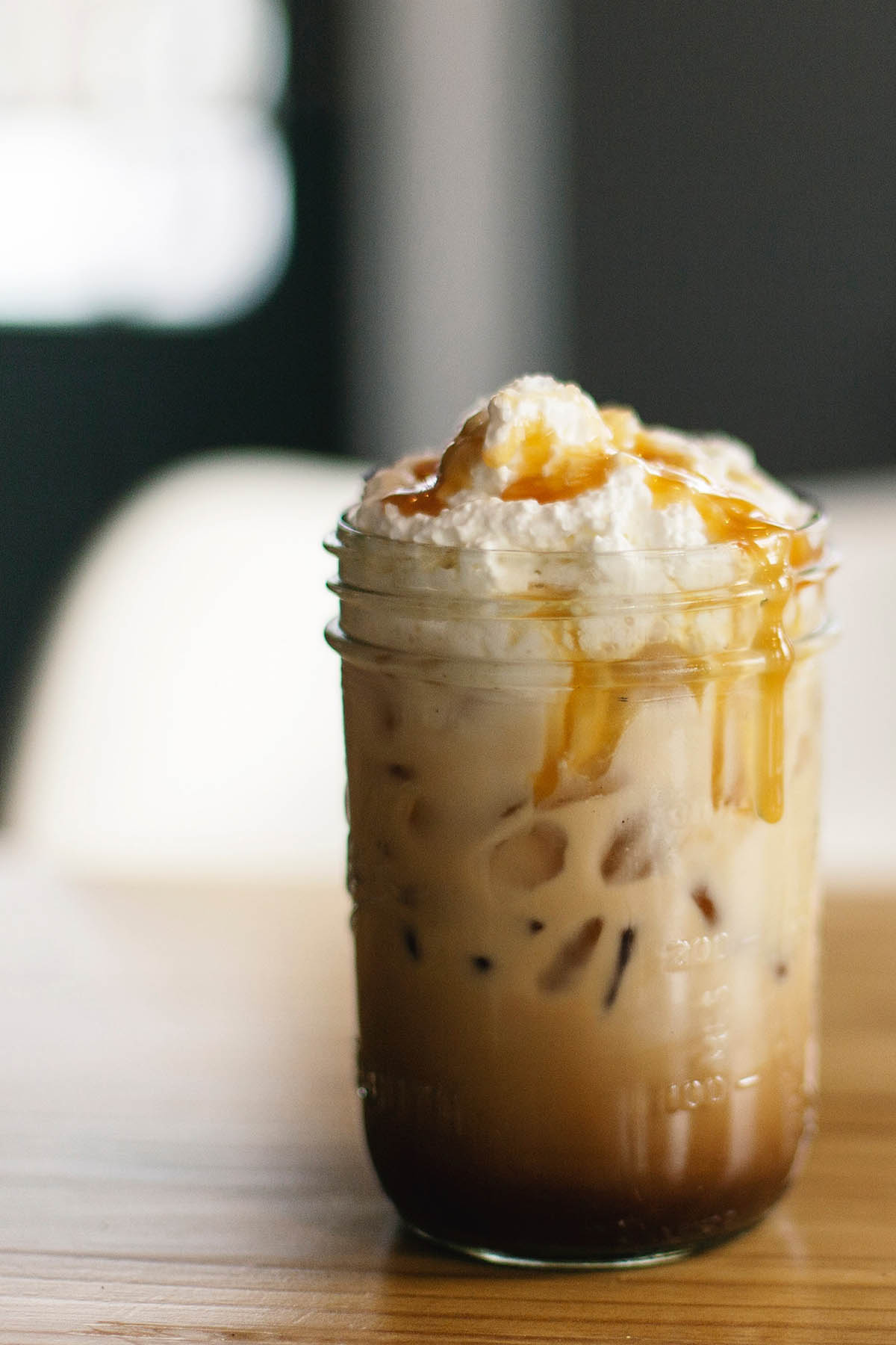 iced coffee topped with whipped cream and caramel drizzle.