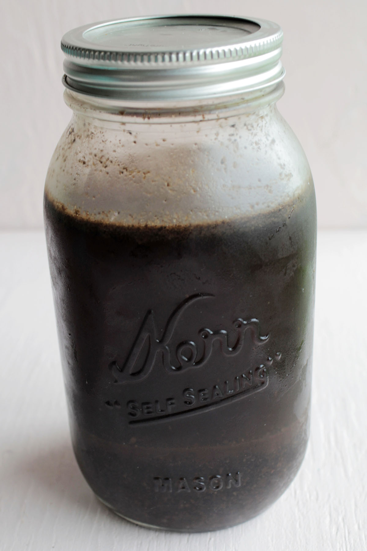mason jar with water and coffee grounds.