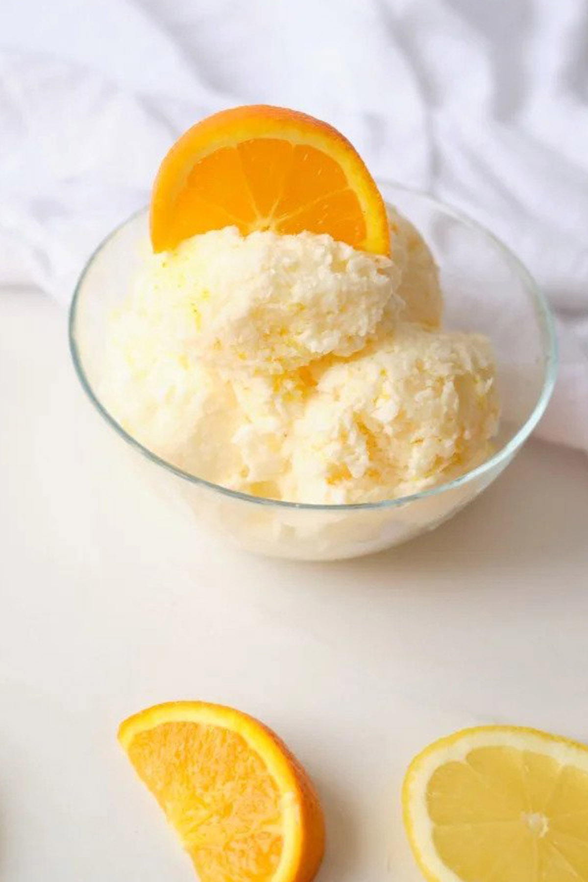 orange ice cream in glass serving bowl.