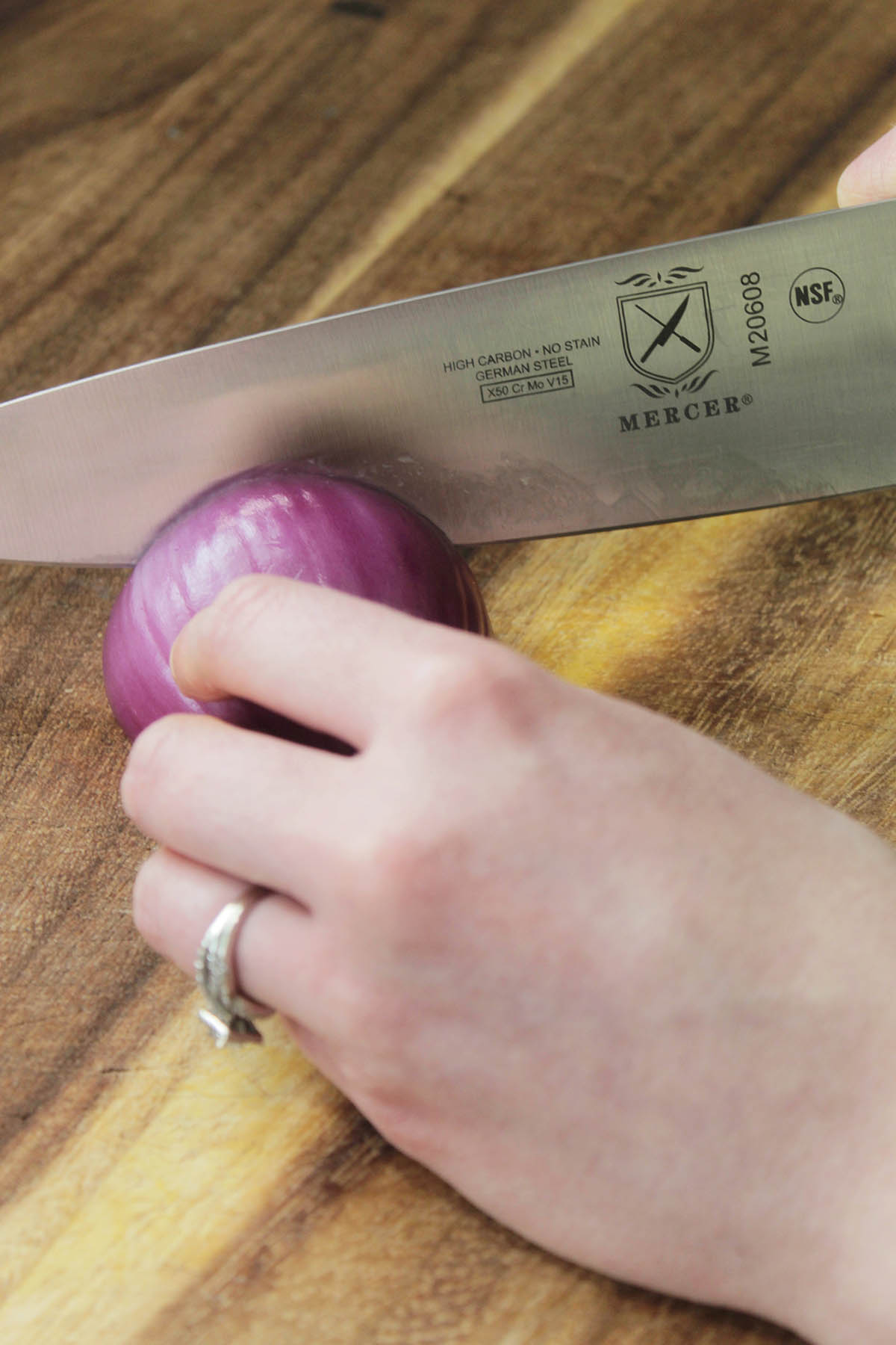 slicing a red onion with a chef's knife.