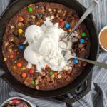 brownie baked in cast iron skillet topped with ice cream.