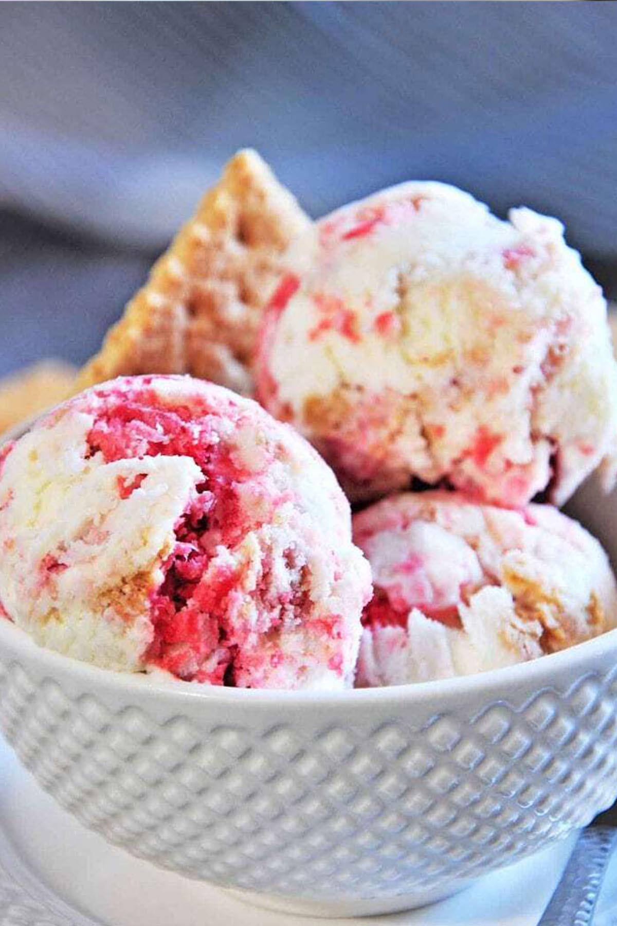 strawberry cheesecake ice cream in a white serving bowl.