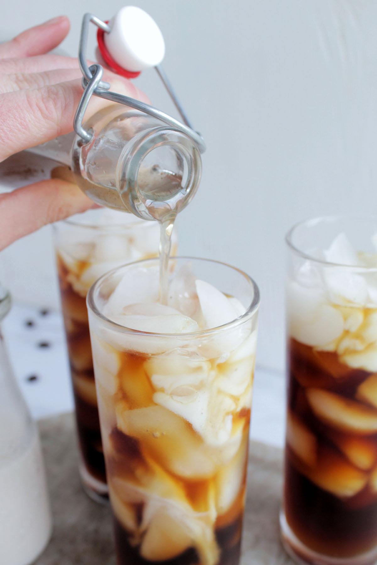 pouring coffee syrup into cold brew coffee.