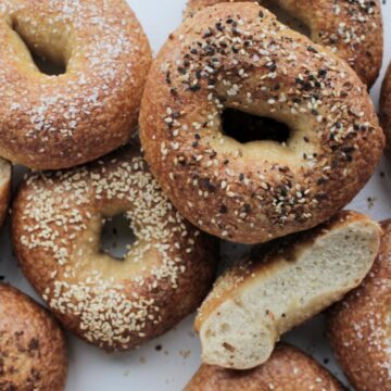 golden brown bagels topped with black and white seeds.