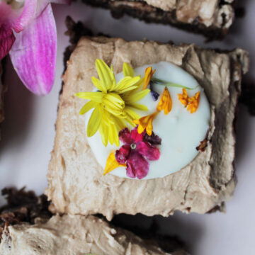 chocolate iced brownie with flower garnish.