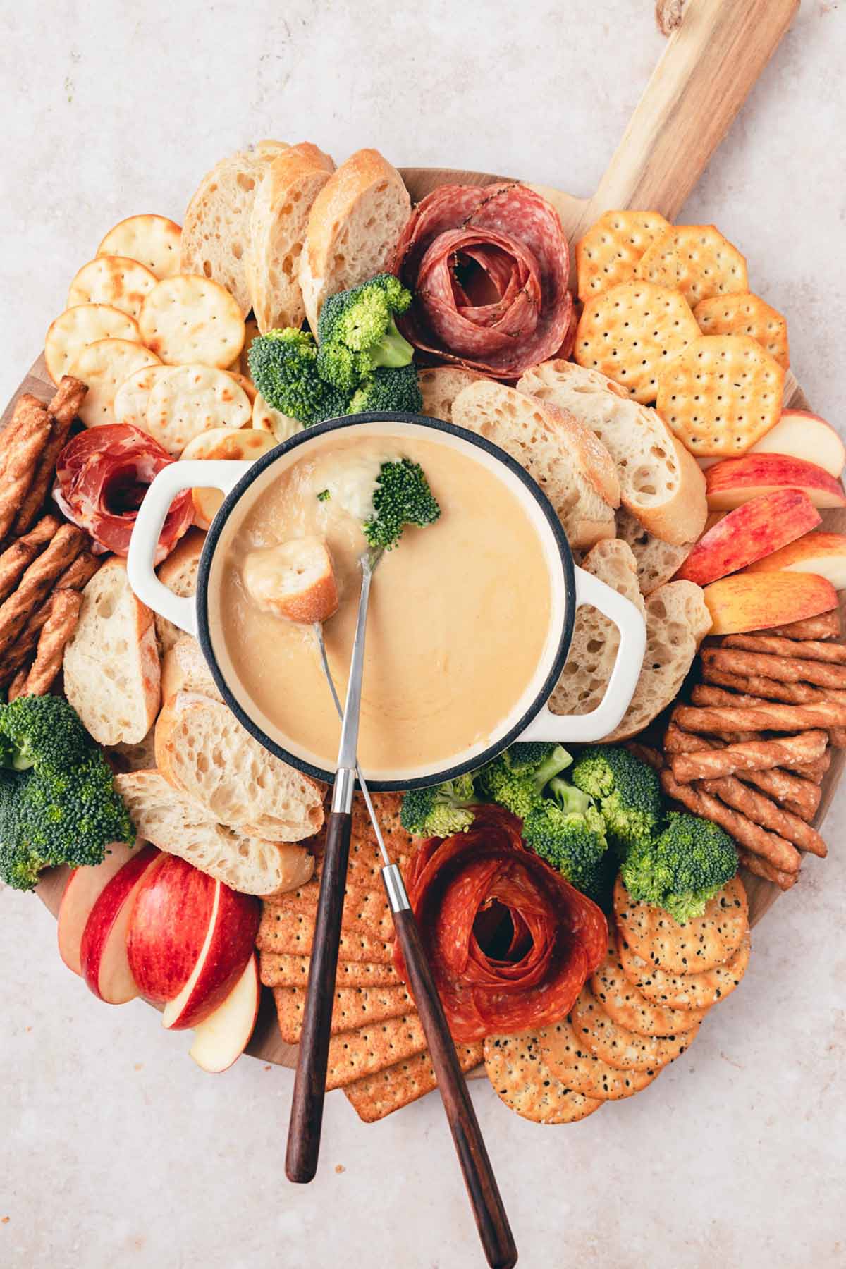 beer cheese fondue dip surrounded by crackers and vegetables.