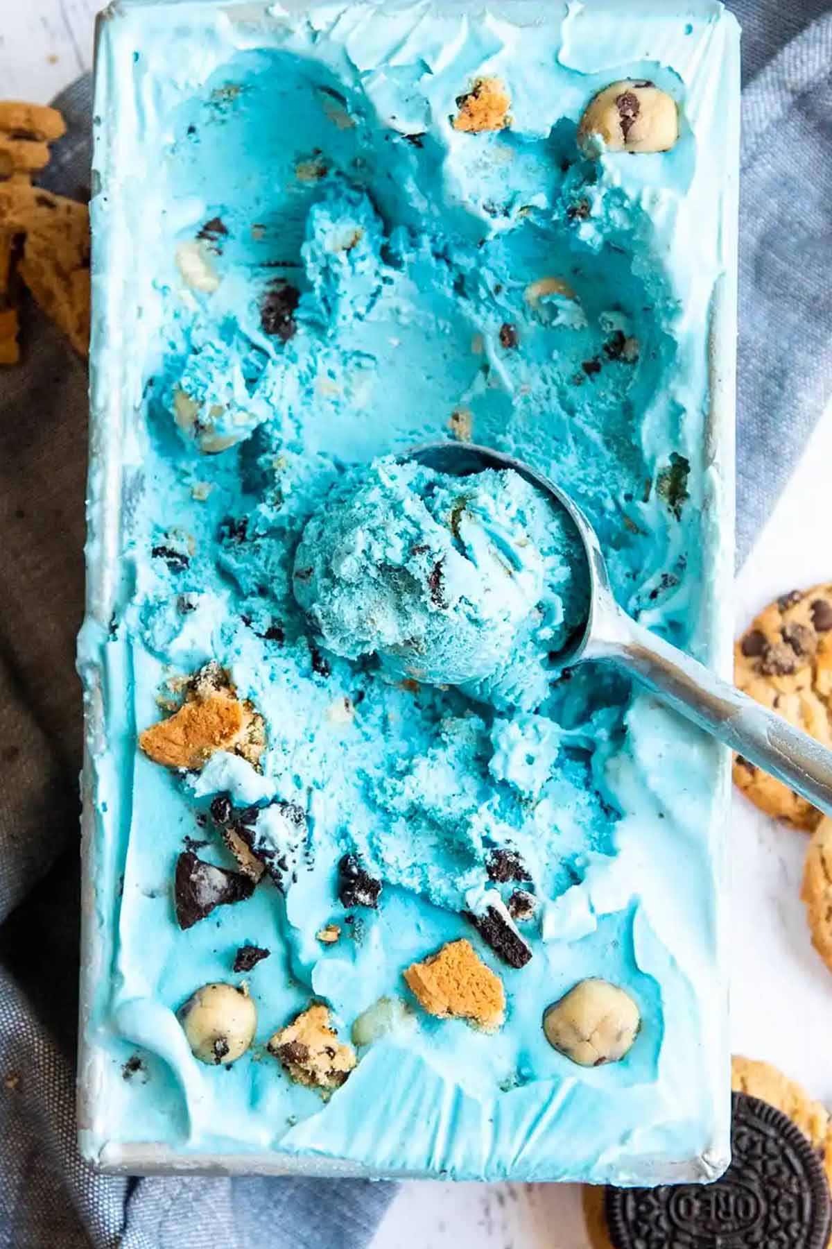 loaf pan holding blue colored ice cream and an ice cream scoop.