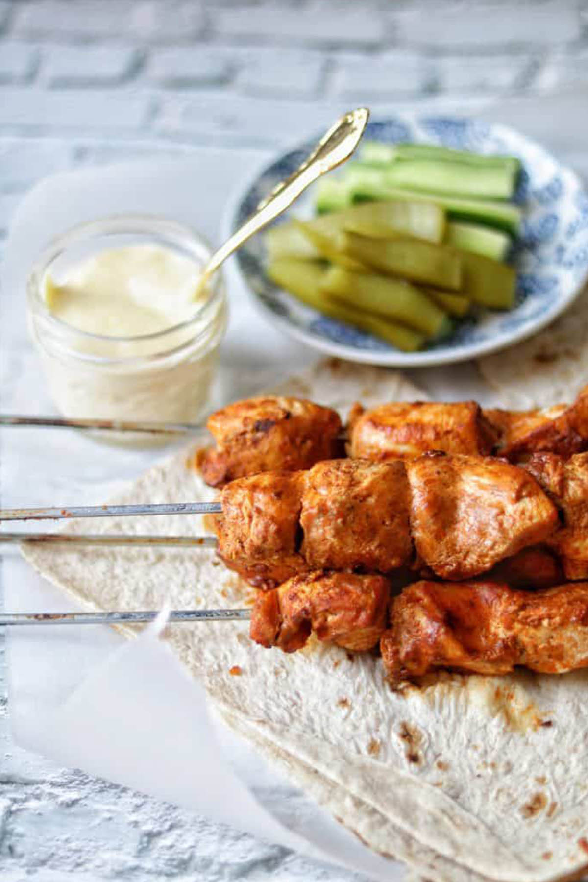 four skewers holding chicken tikka.