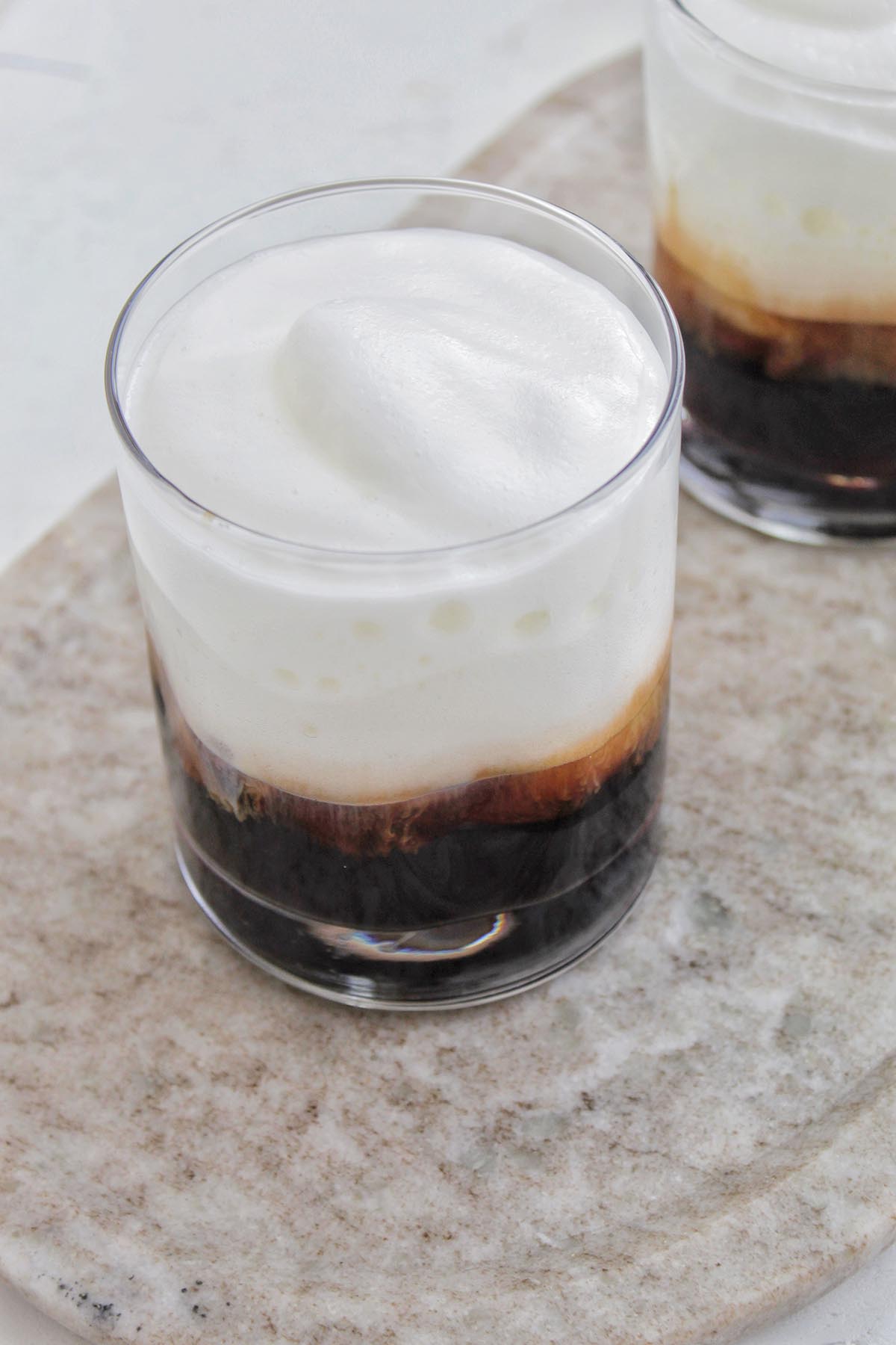 lowball glass filled with coffee and cold foam.