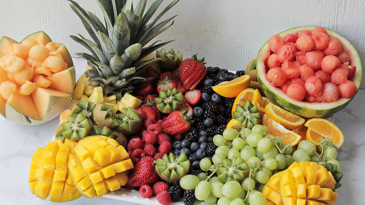 fruit platter holding various summer fruits.