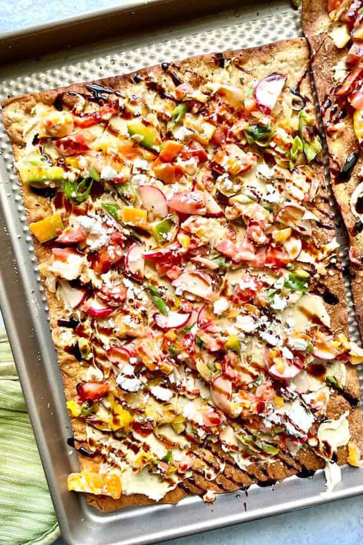 flatbread loaded with toppings and balsamic glaze.