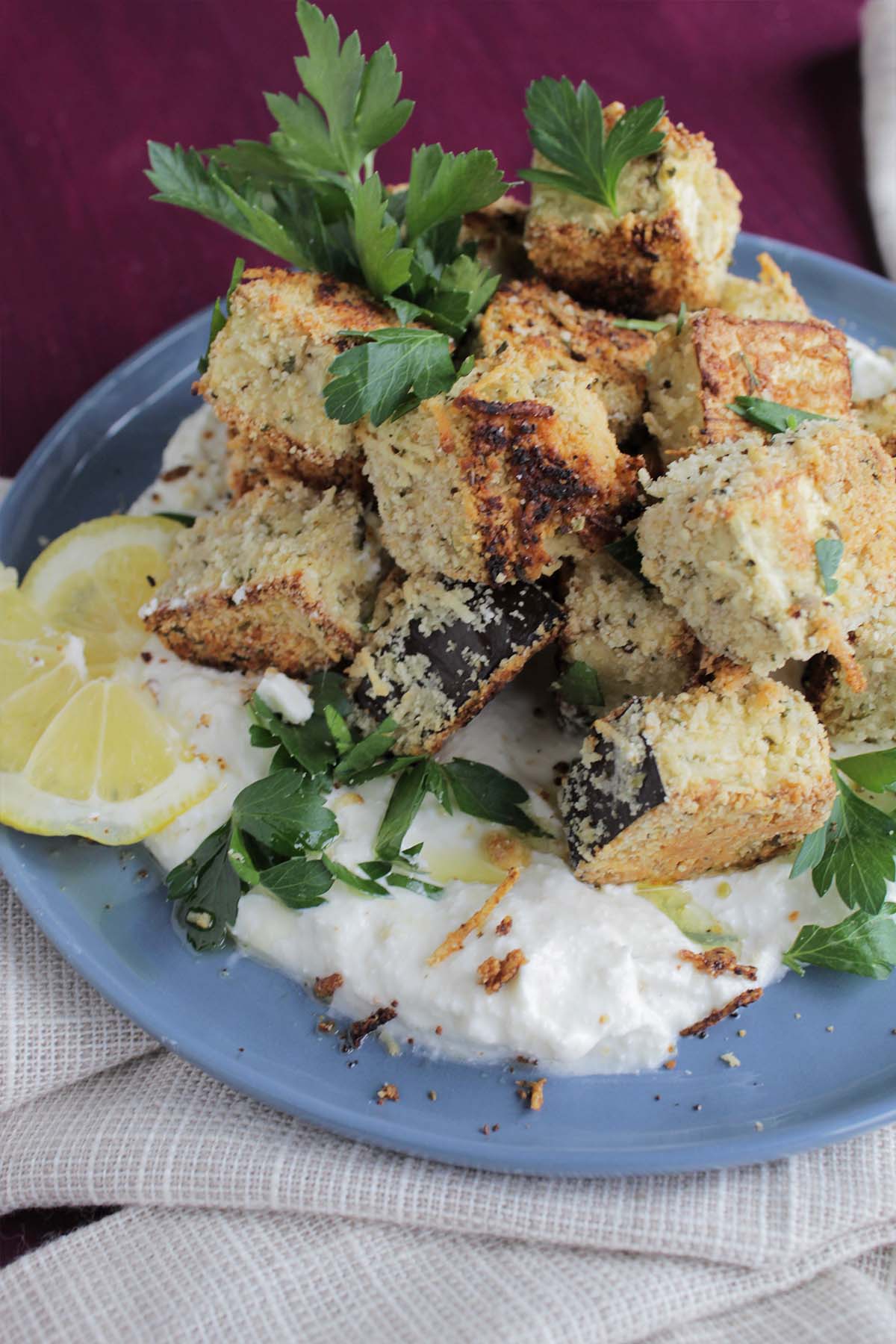 breaded eggplant cubes stacked on top of whipped feta dip.