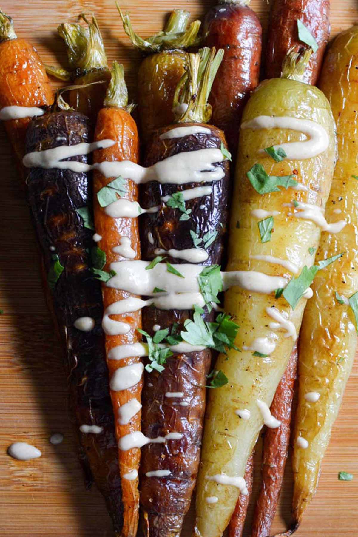 colorful roasted carrots drizzled with tahini sauce.