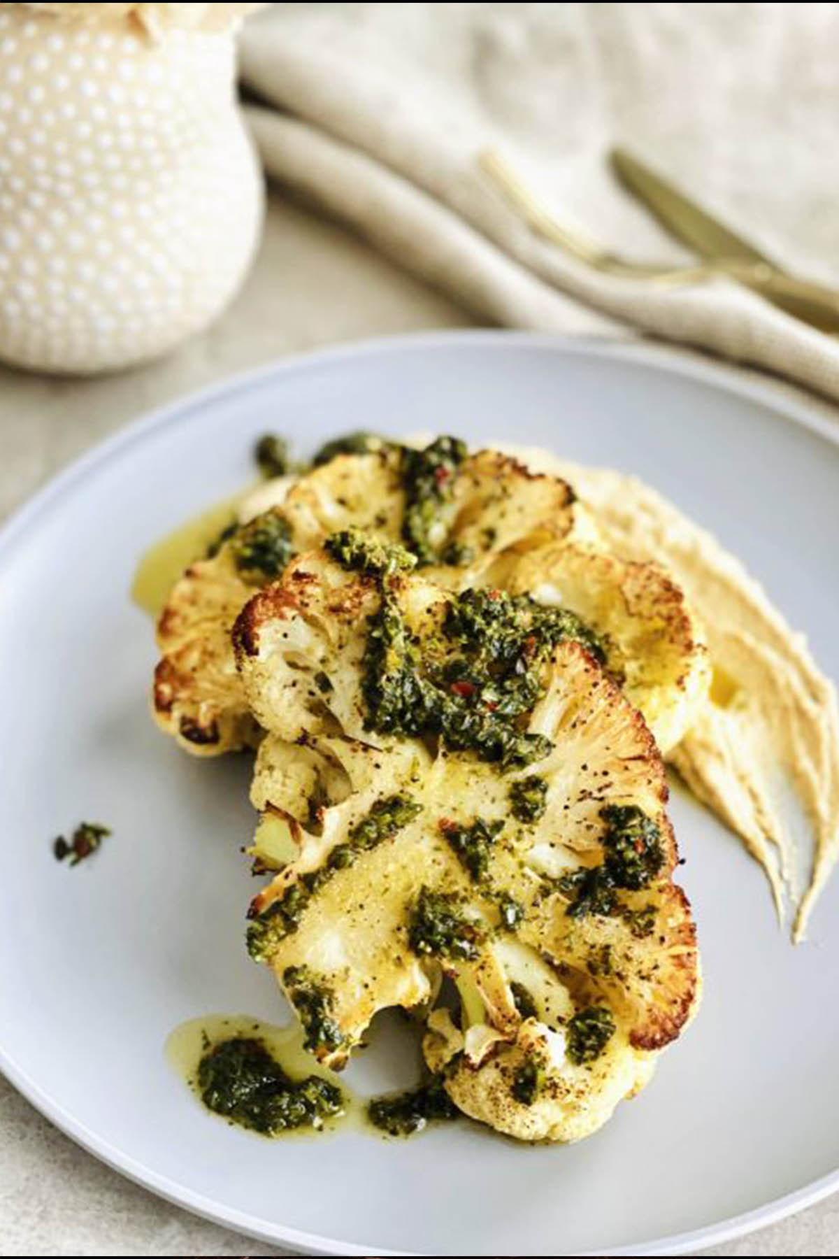 cauliflower steaks topped with pesto.