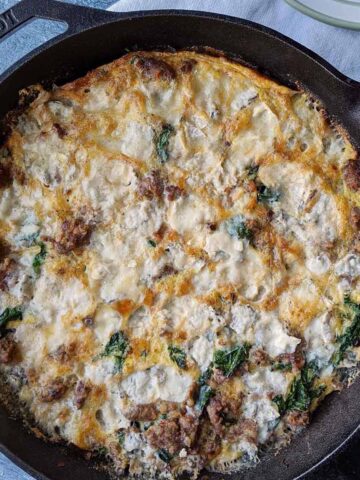 sausage and kale egg frittata in a cast iron skillet.