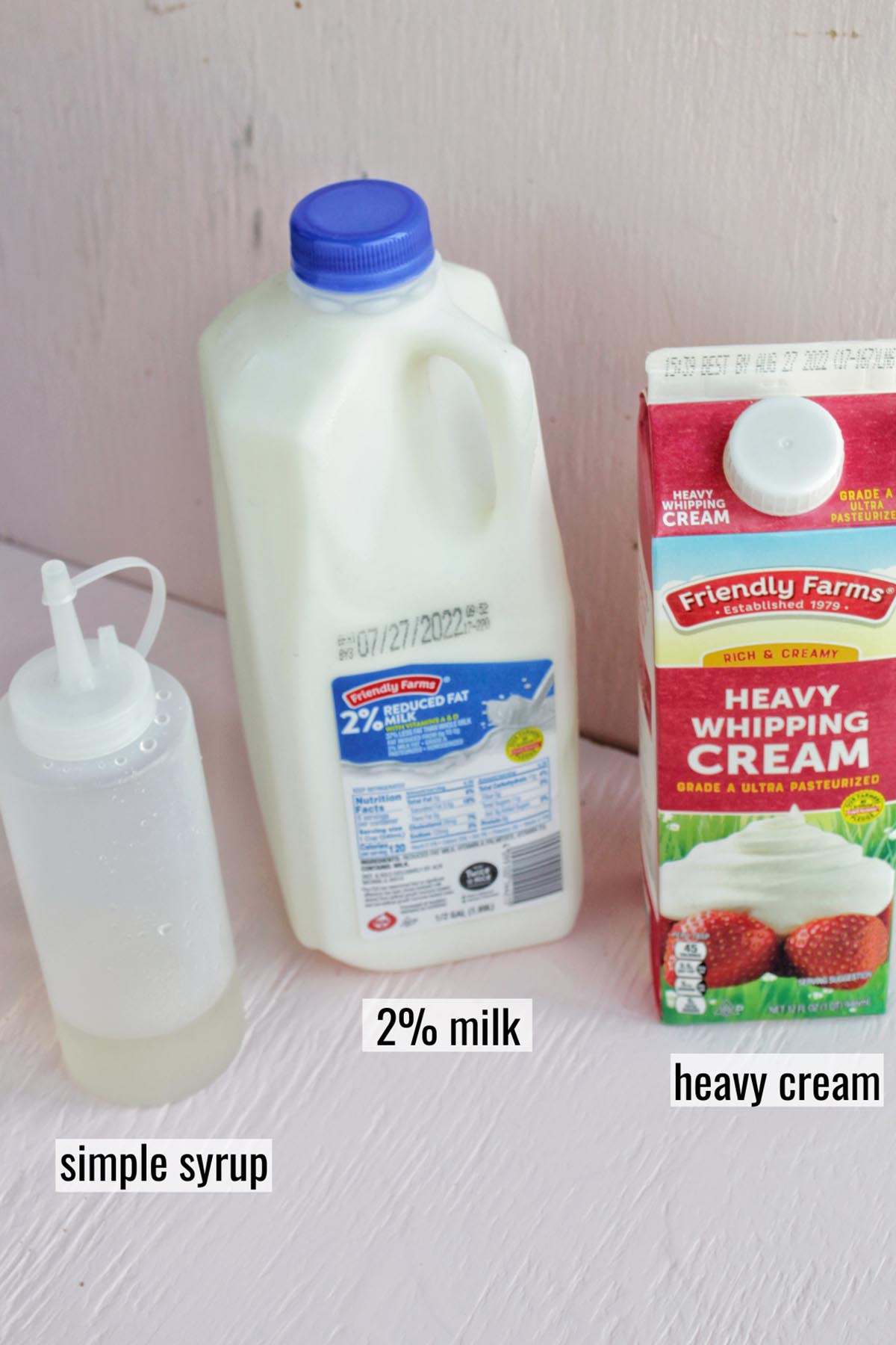 bottle of simple syrup, milk, and heavy cream with labels.