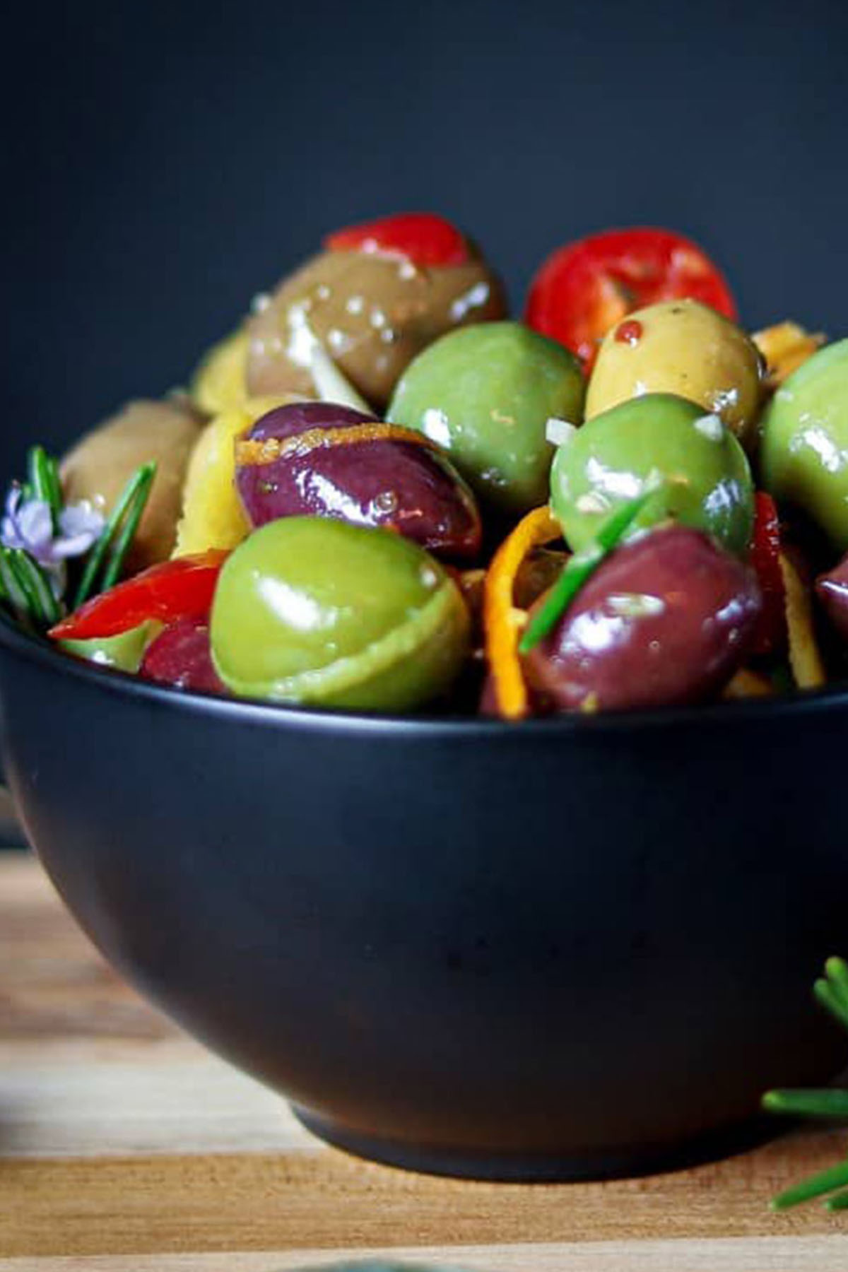 green and purple olives in a blue serving bowl.