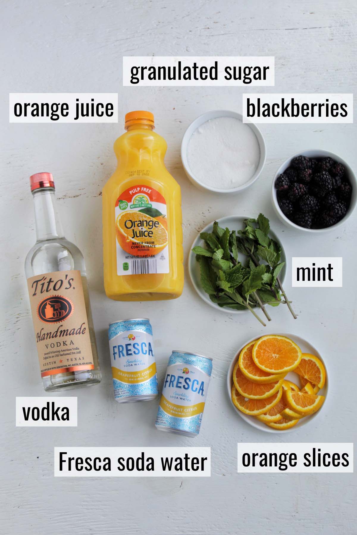 ingredients for Tito's blackberry orange cocktail with labels.