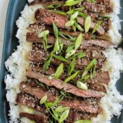 serving tray topped with rice and grilled steak.
