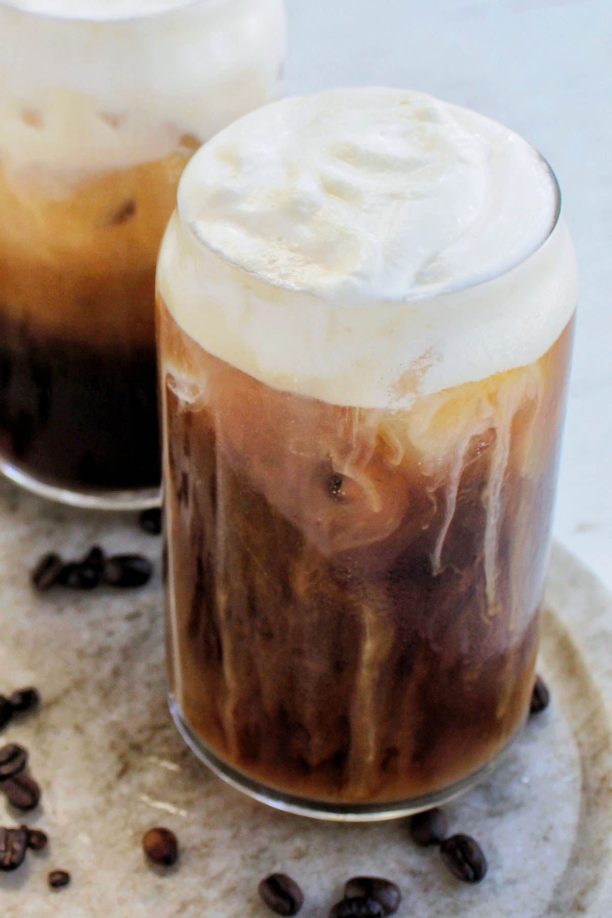 glass filled with cold brew coffee and cold foam on top.