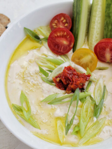 bowl with whipped feta dip, cherry tomatoes, and cucumber.