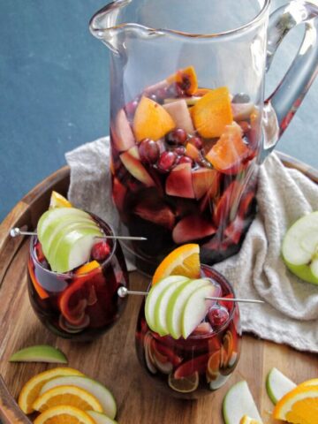 two wine glasses and pitcher filled with red wine sangria.