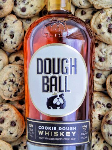 Dough Ball whiskey cocktail bottle on top of chocolate chip cookies.