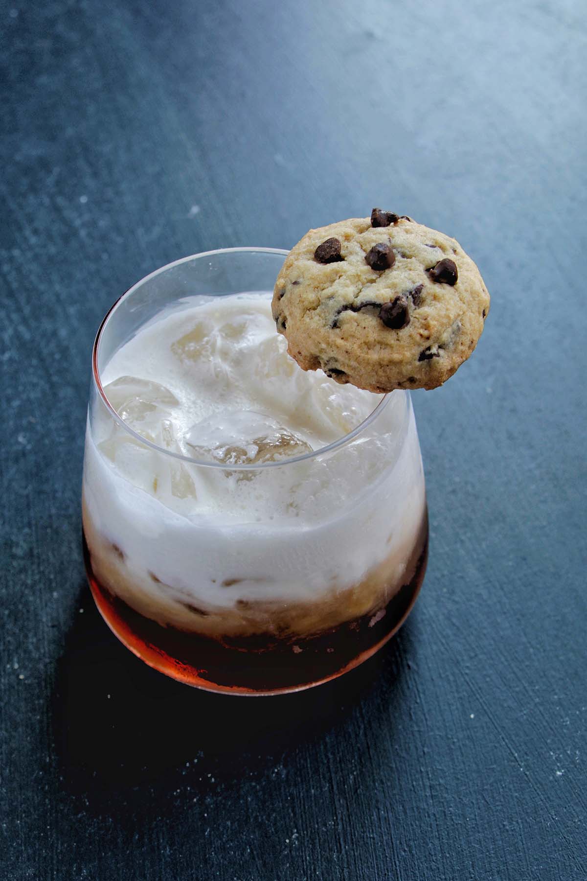 white Russian cocktail in a rocks glass garnished with a cookie.