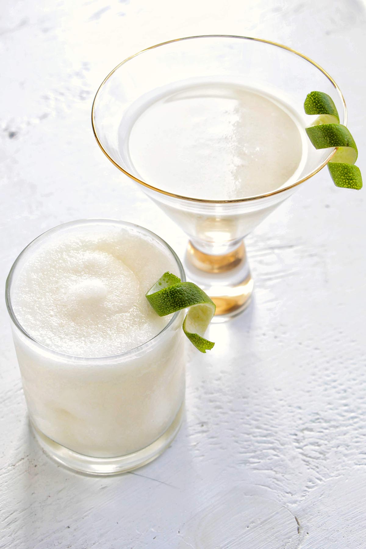 two coconut daiquiris with lime twist garnish.