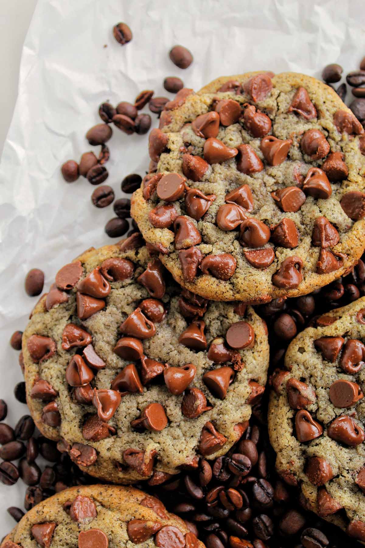 chocolate chip cookies laying on coffee beans.