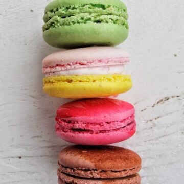 four colorful macarons stacked on top of each other.