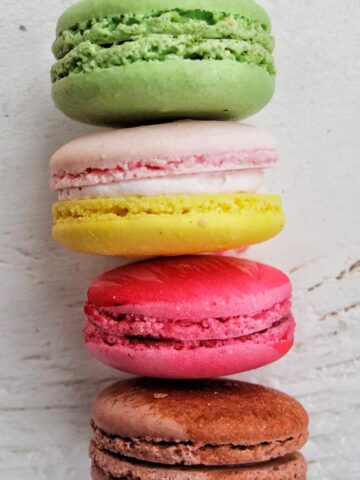 four colorful macarons stacked on top of each other.