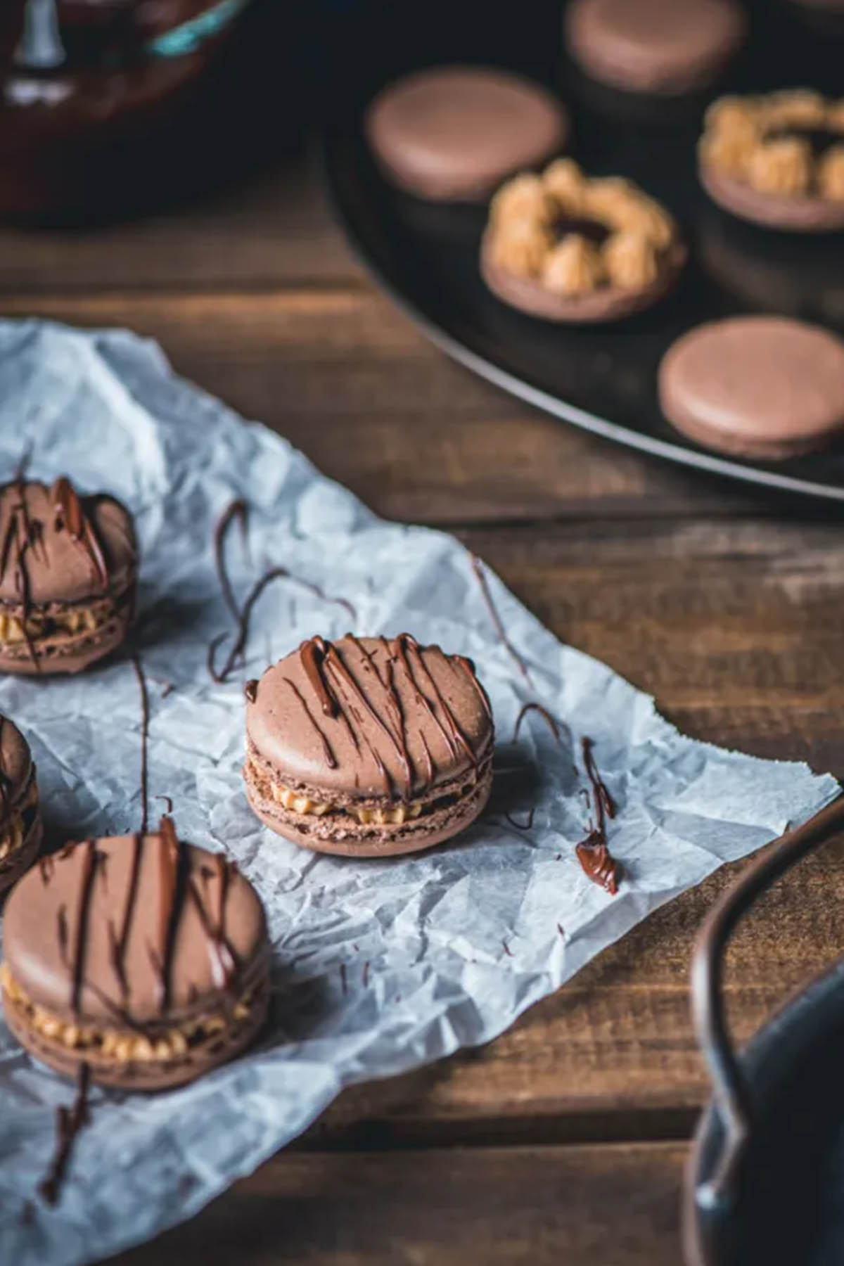 chocolate peanut butter macarons on a piece of parchment paper.
