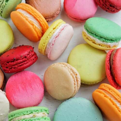 various colored macarons on a white background.