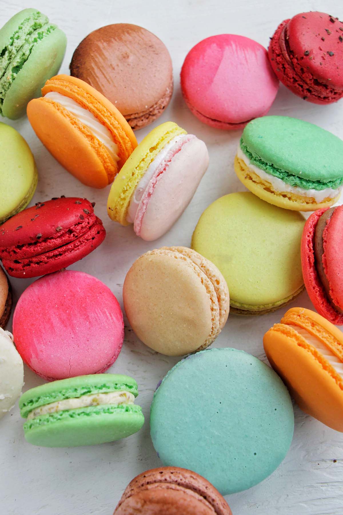 various colored macarons on a white background.
