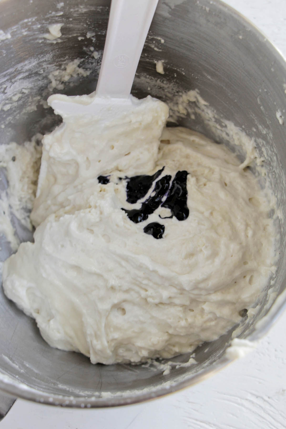 macaron batter with food coloring in a mixing bowl.