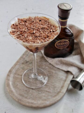 chocolate martini on a serving tray next to Godiva chocolate liqueur bottle.