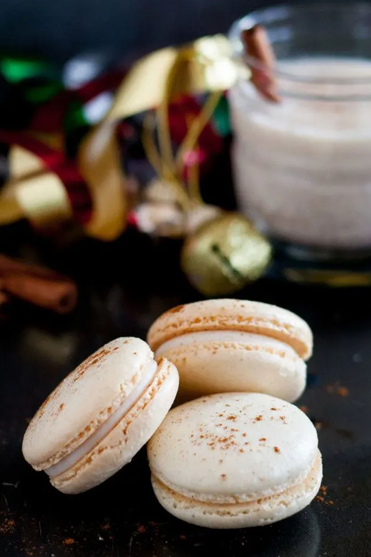 egg nog flavored white macaron shells dusted with cinnamon.