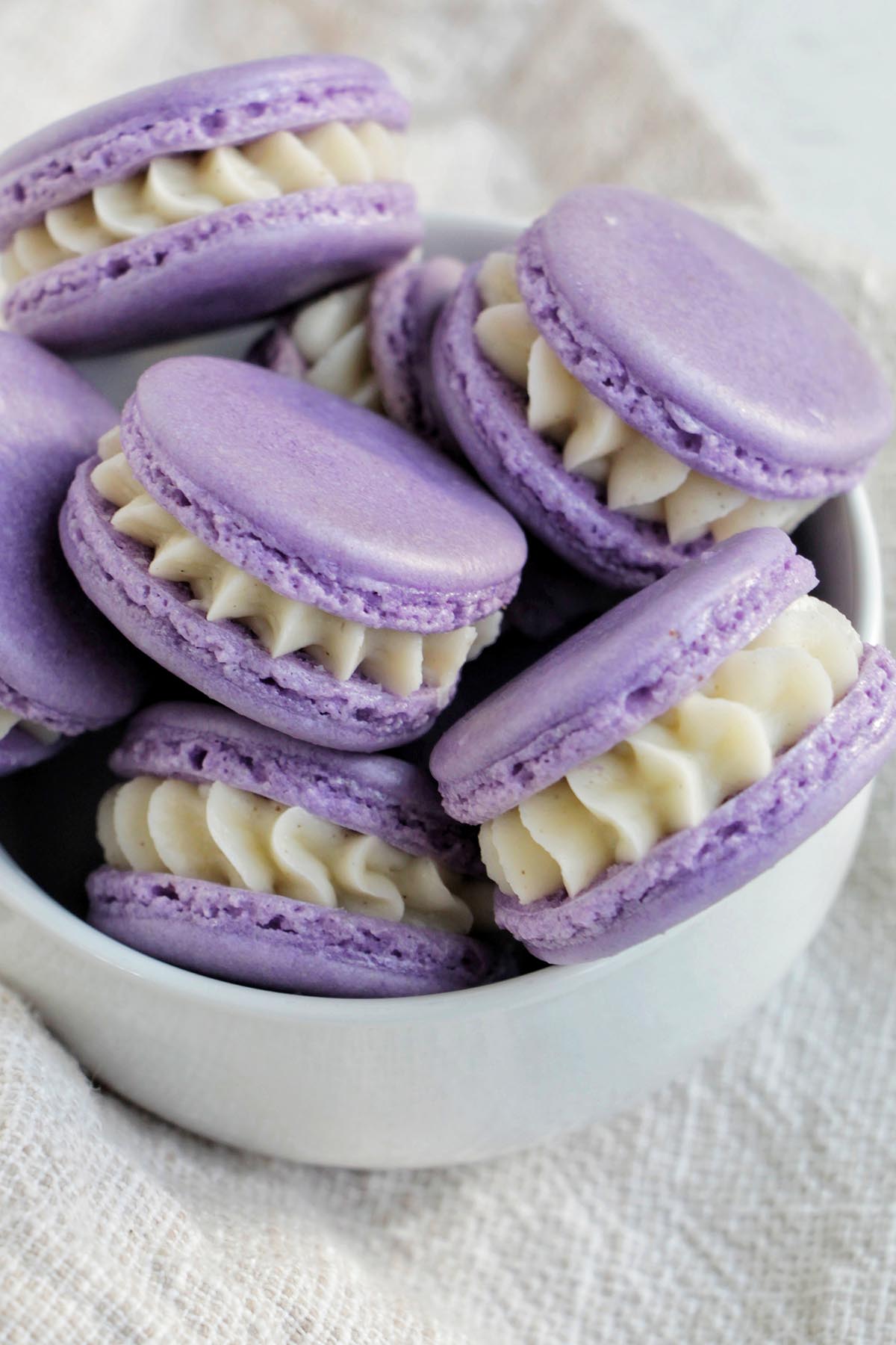 bowl filled with purple macarons filled with buttercream.