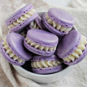bowl filled with purple macarons filled with buttercream.