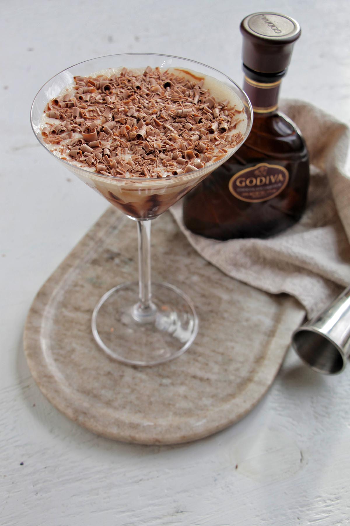 chocolate martini on a serving tray next to Godiva chocolate liqueur bottle.