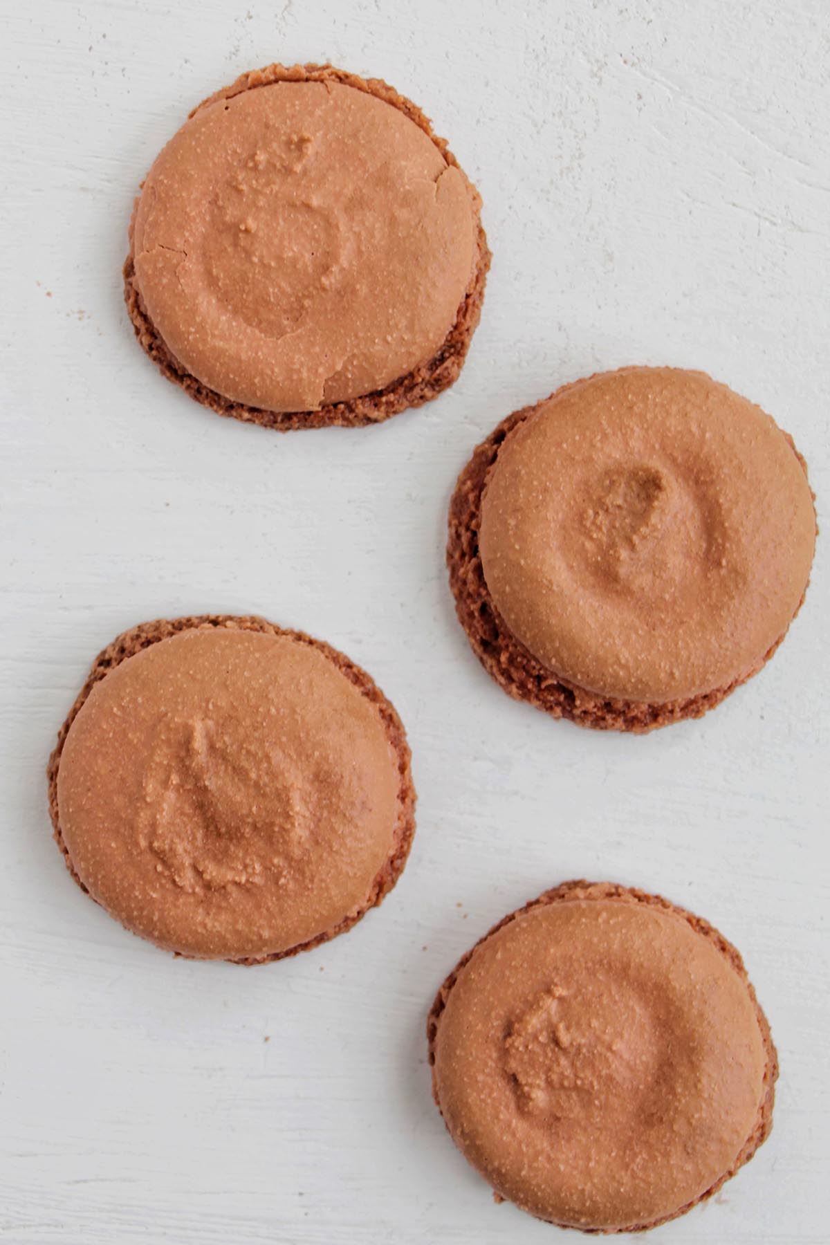 brown macaron shells with feet that spread.