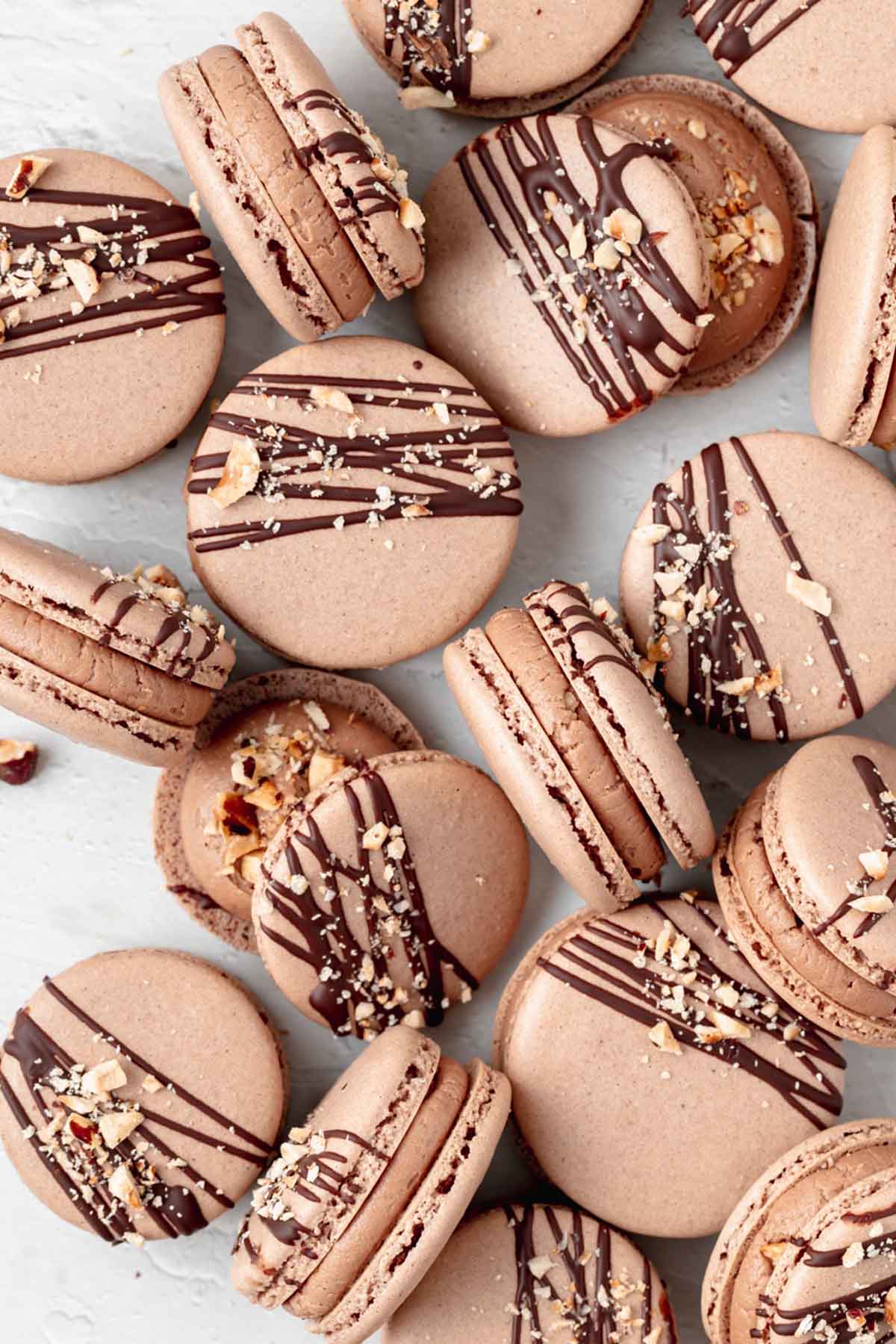 Nutella macaron shells drizzled with chocolate.