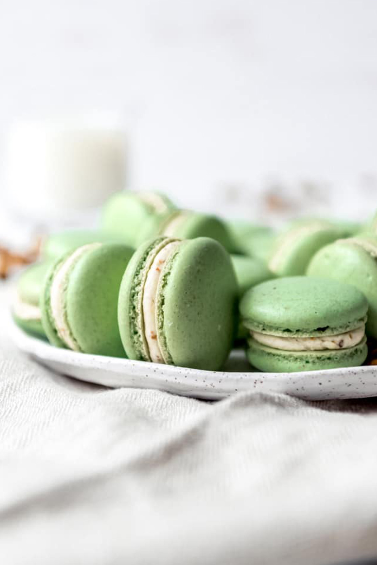 green shelled pistachio macarons on a plate.