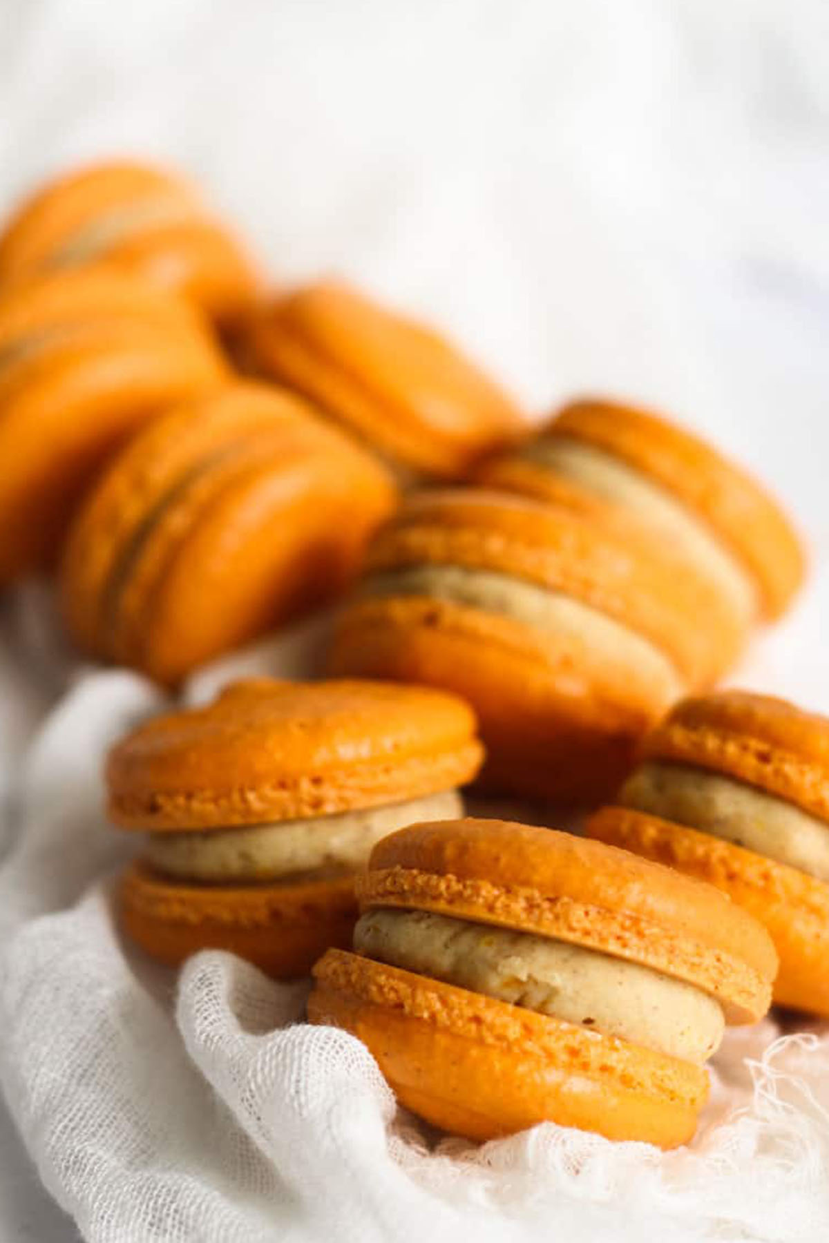 pumpkin spice flavored macarons with orange shells.